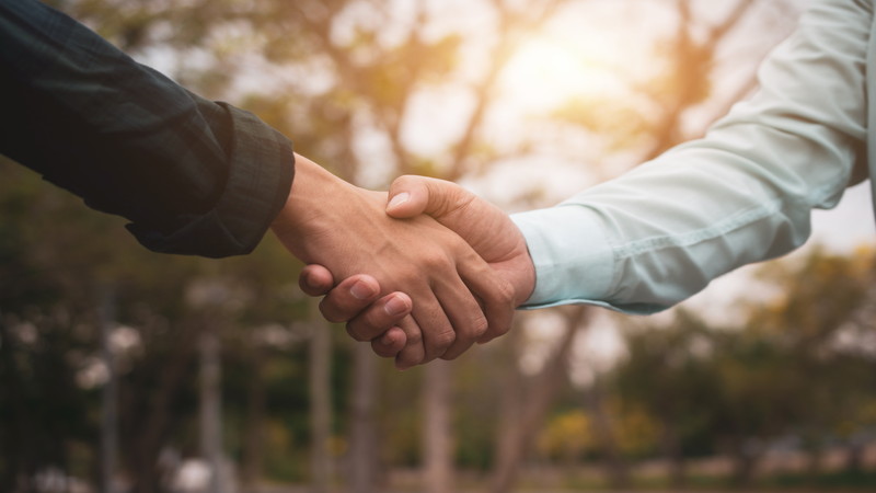 夕日を背に握手